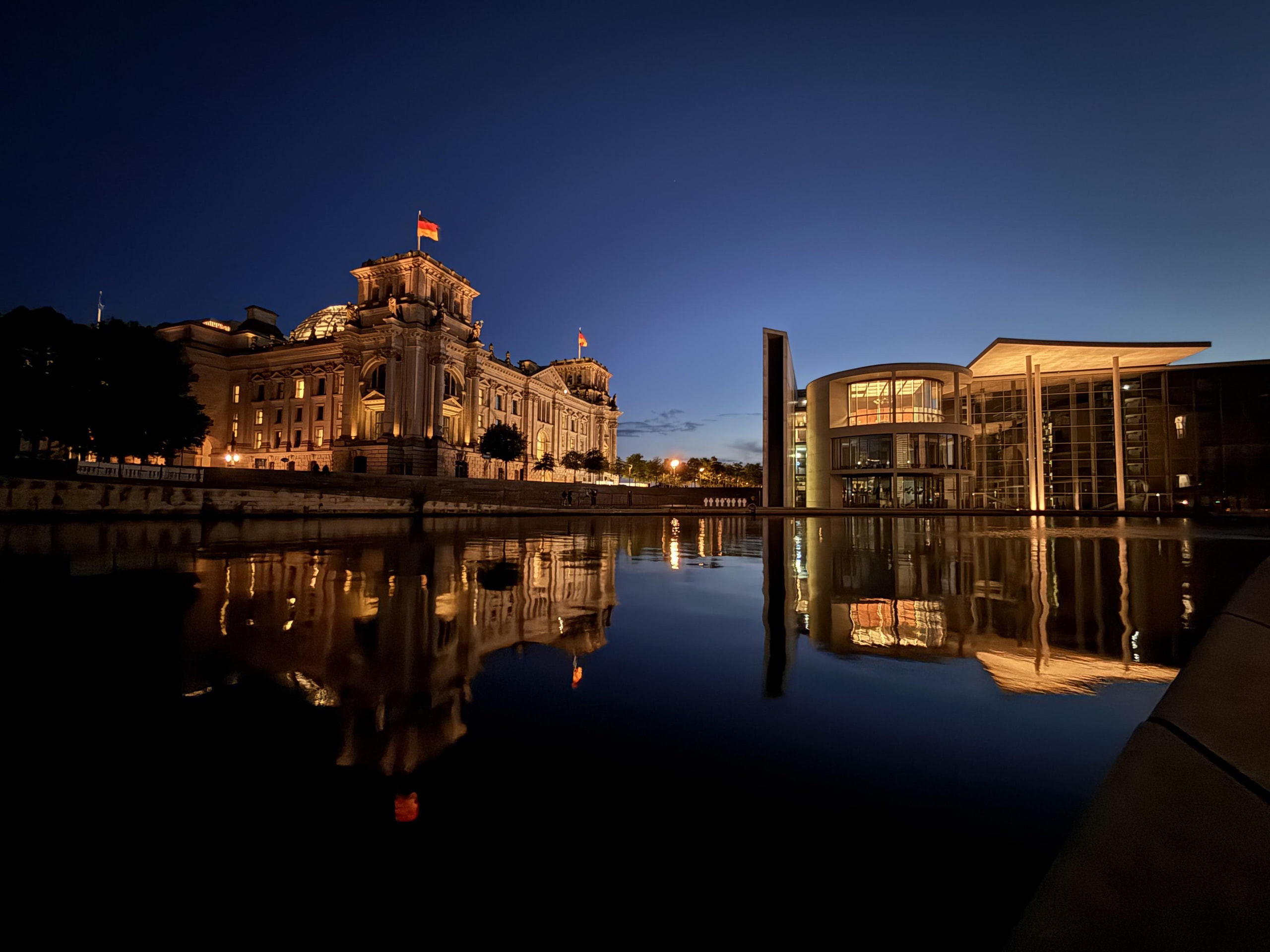The Reichstag and Paul-Löbe-Haus mirrored in the Spree at night.