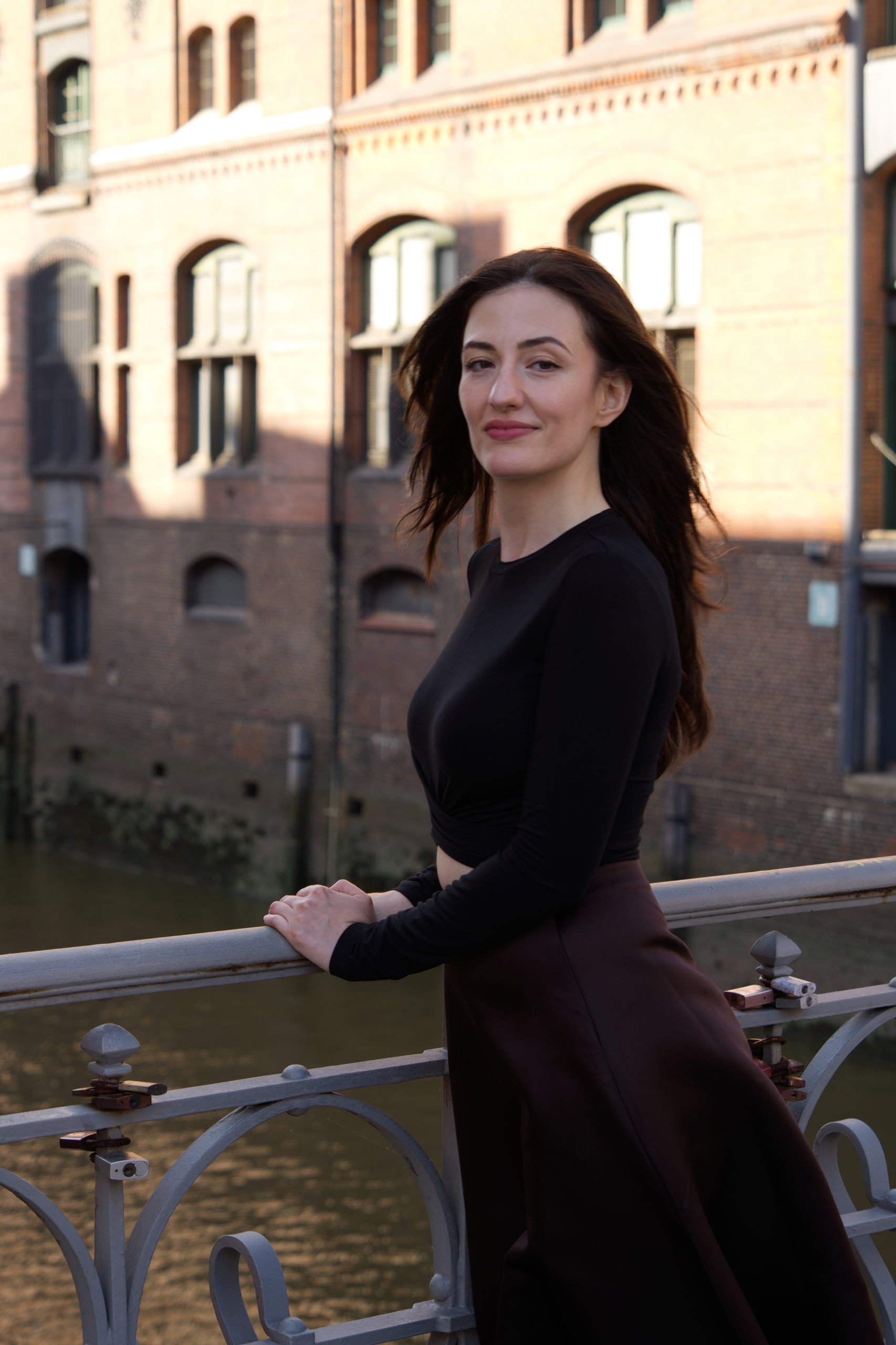 Breshna Hamid Khan resting her hands on a canal railing in Hamburg's Speicherstadt.