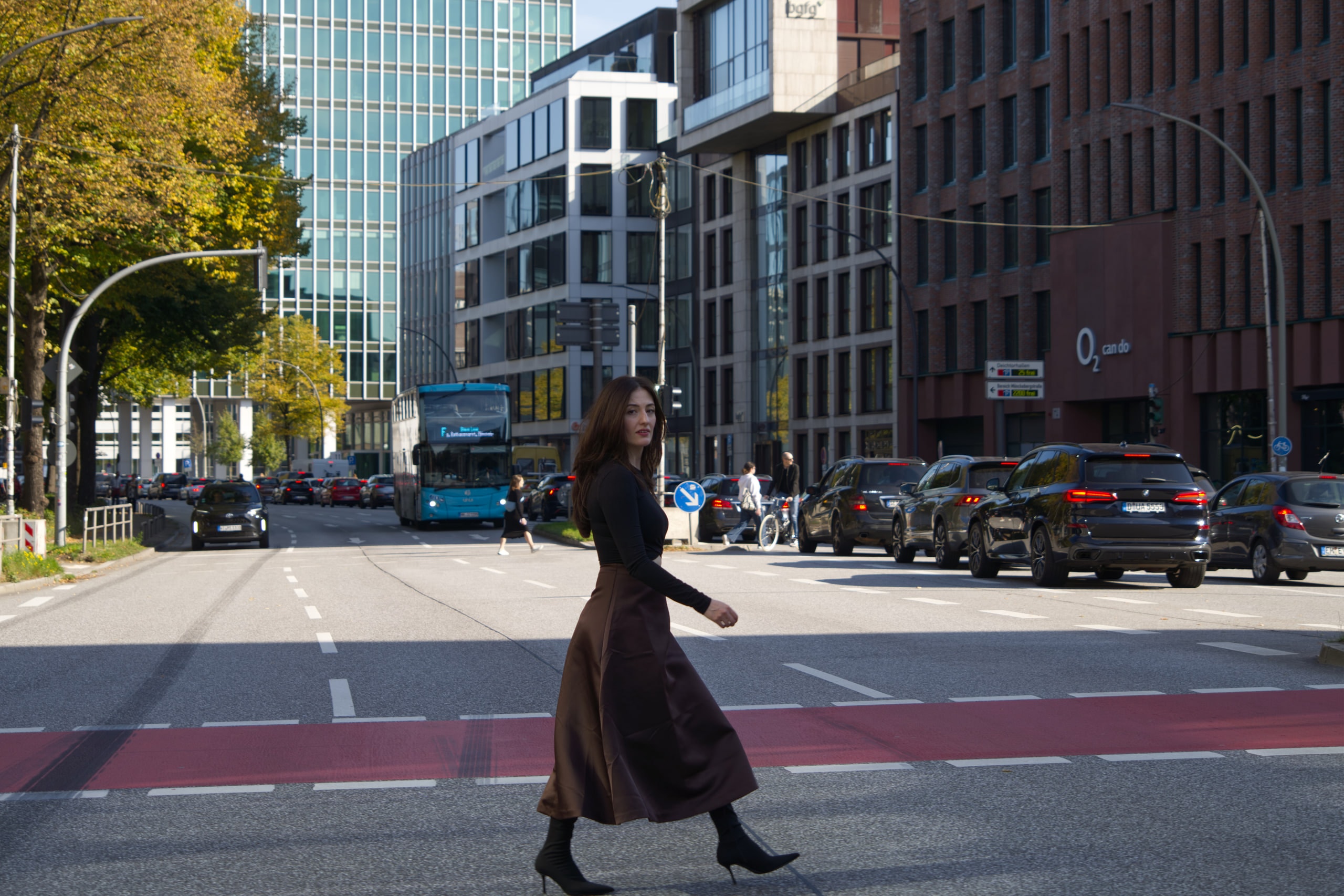 Breshna Hamid Khan turning toward the camera while crossing a Hamburg street.