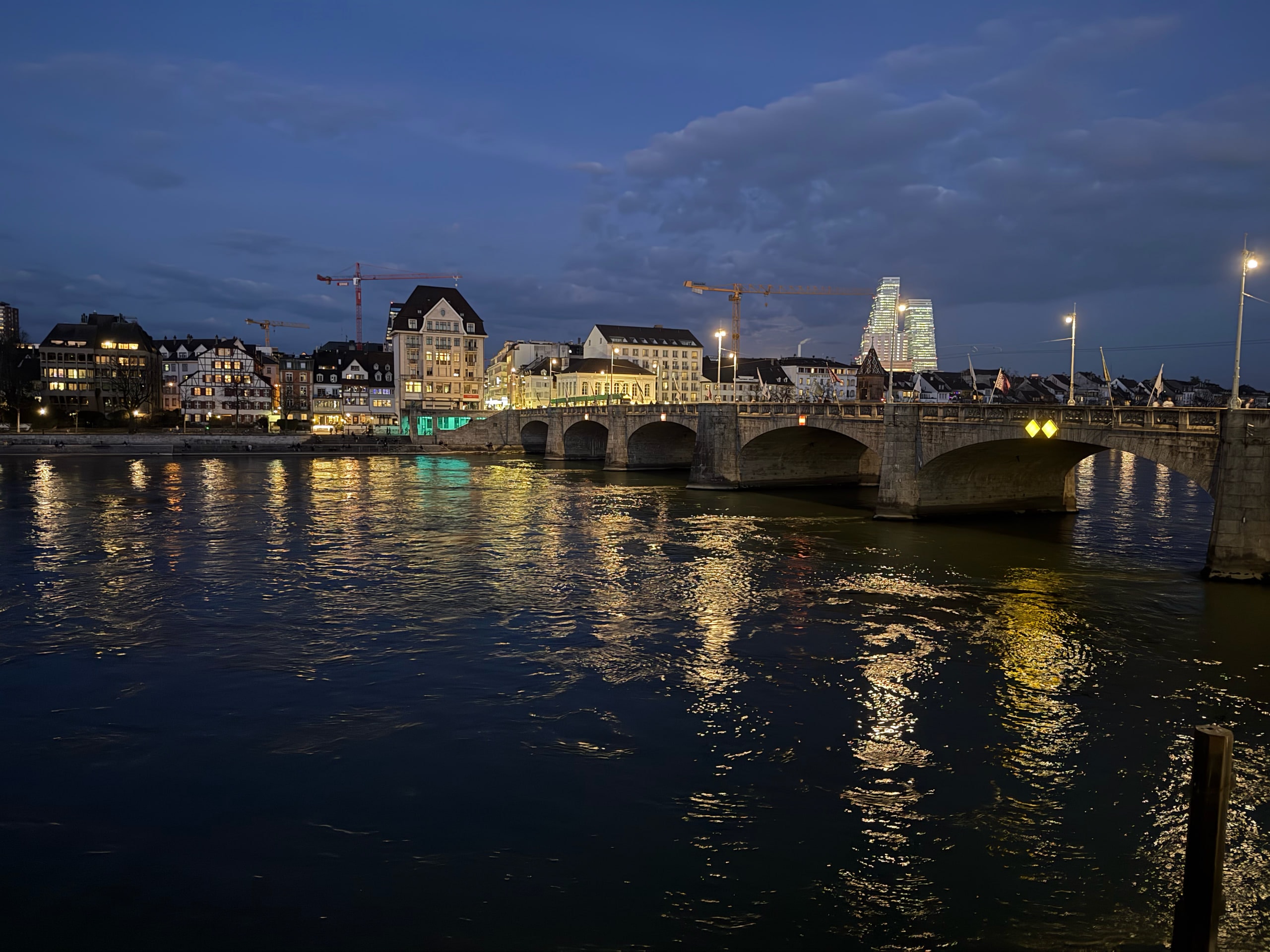The Mittlere Brücke and riverside buildings reflected at blue hour.