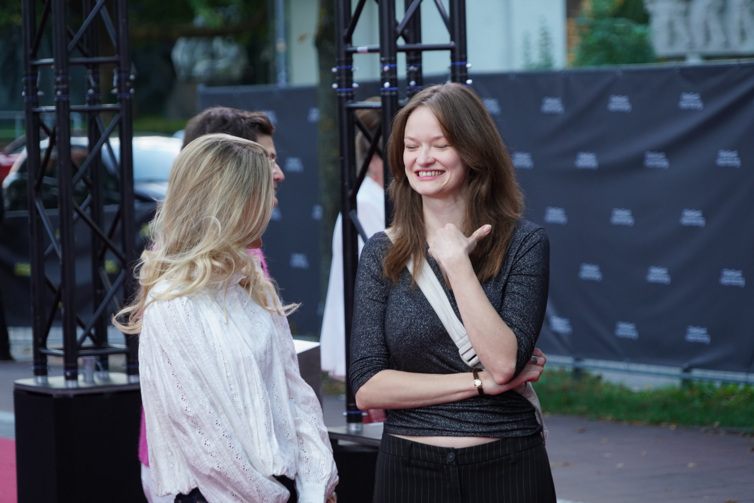 Members of the LORD team sharing a smiling conversation beside the red carpet.