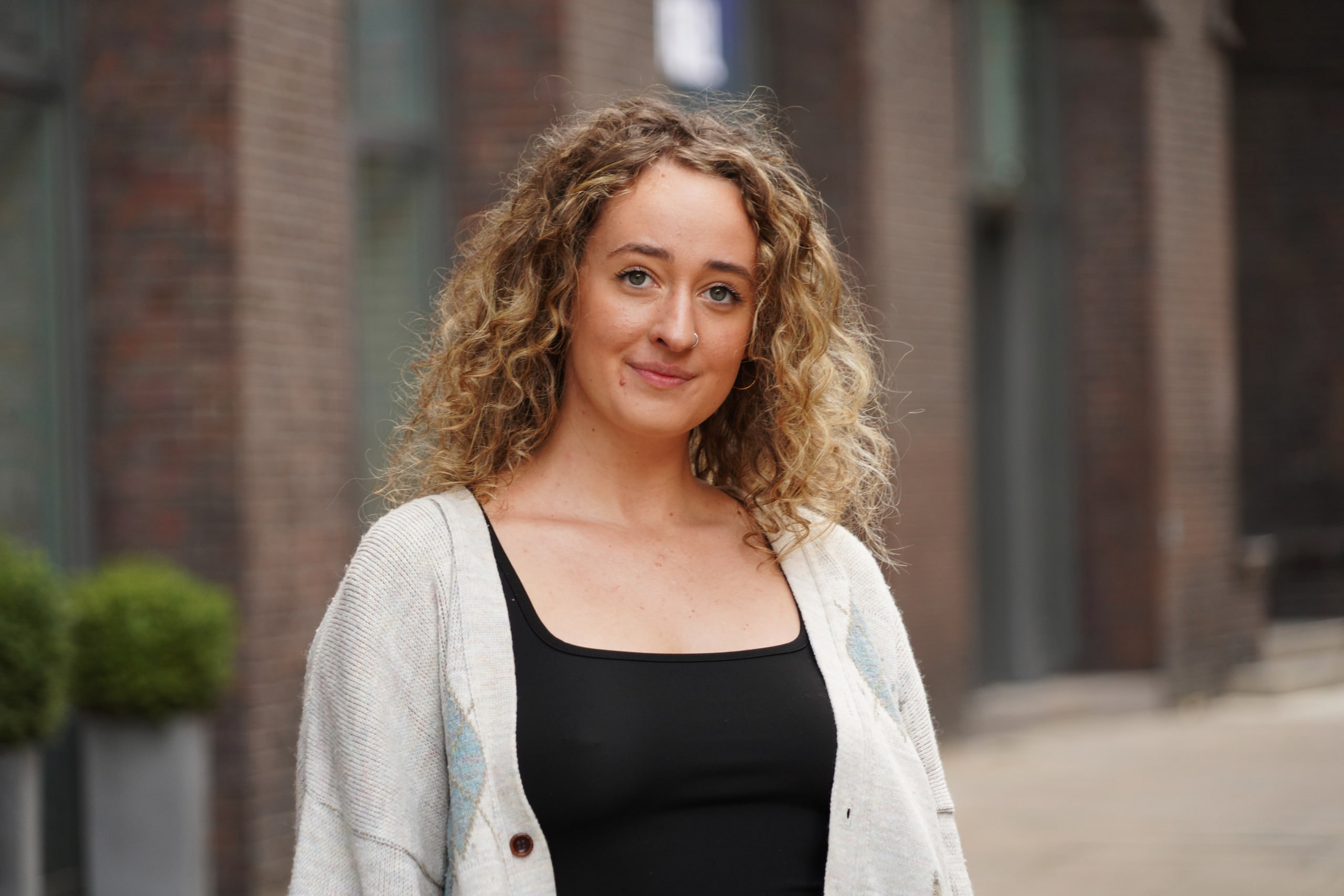 Close portrait of Larissa Kählert in soft light, with Hamburg's brick arcades behind her.