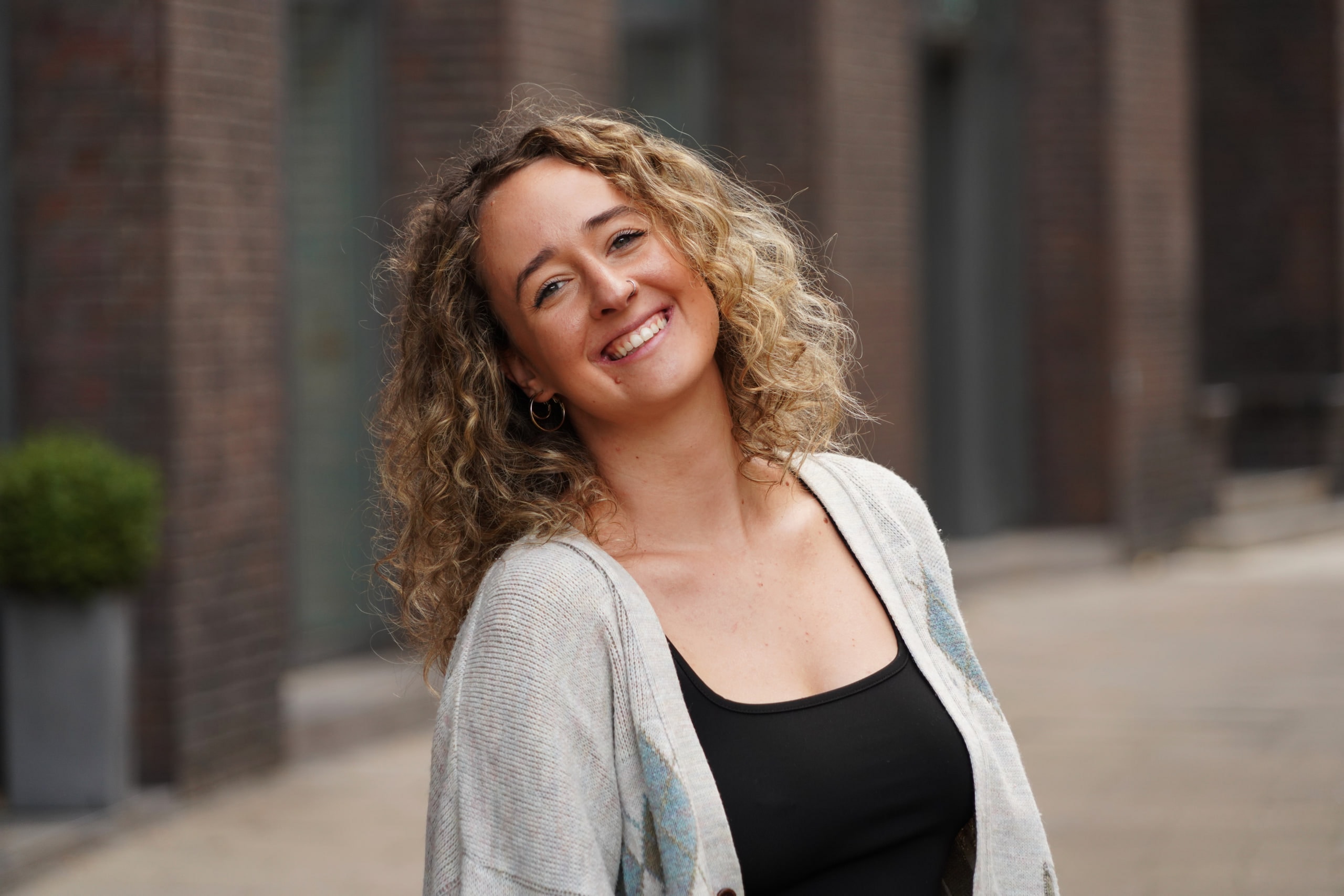 Larissa Kählert smiling with her head tilted, brick arcades softened behind her.