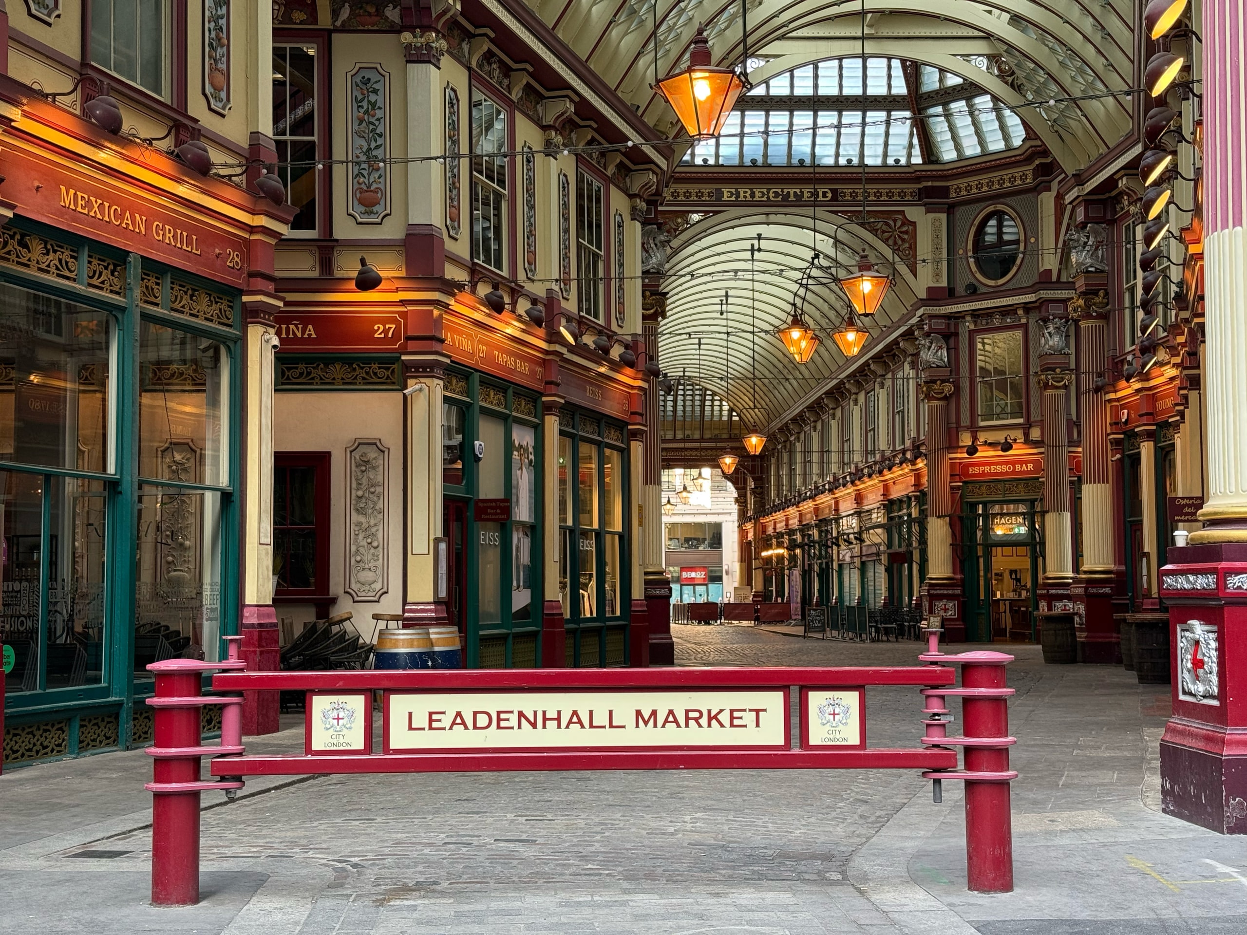 The painted ironwork and empty arcade of Leadenhall Market.