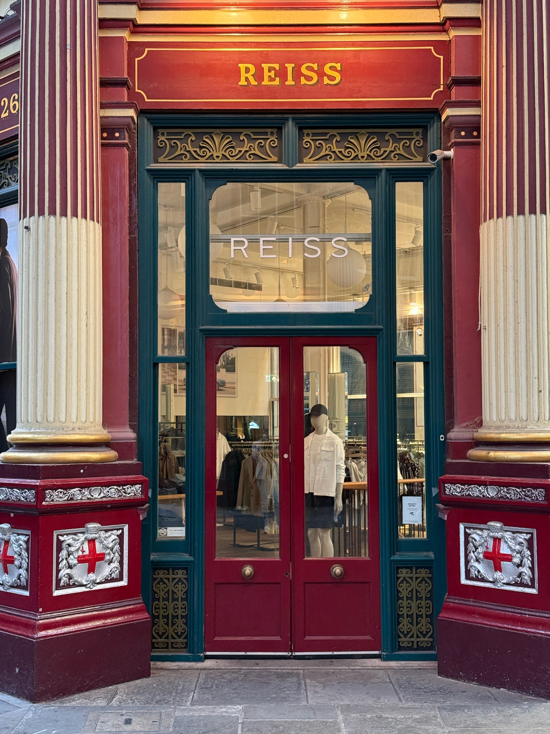 A red and gold shopfront in the empty market arcade.