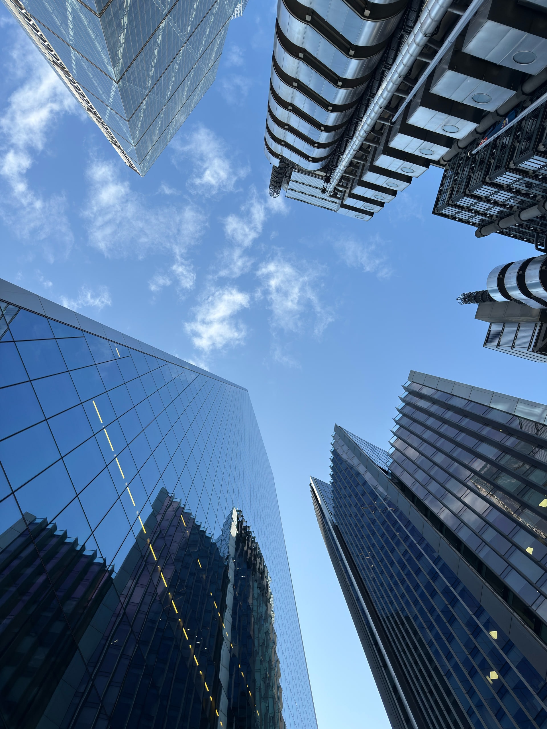 Glass towers of the City seen from street level against open sky.