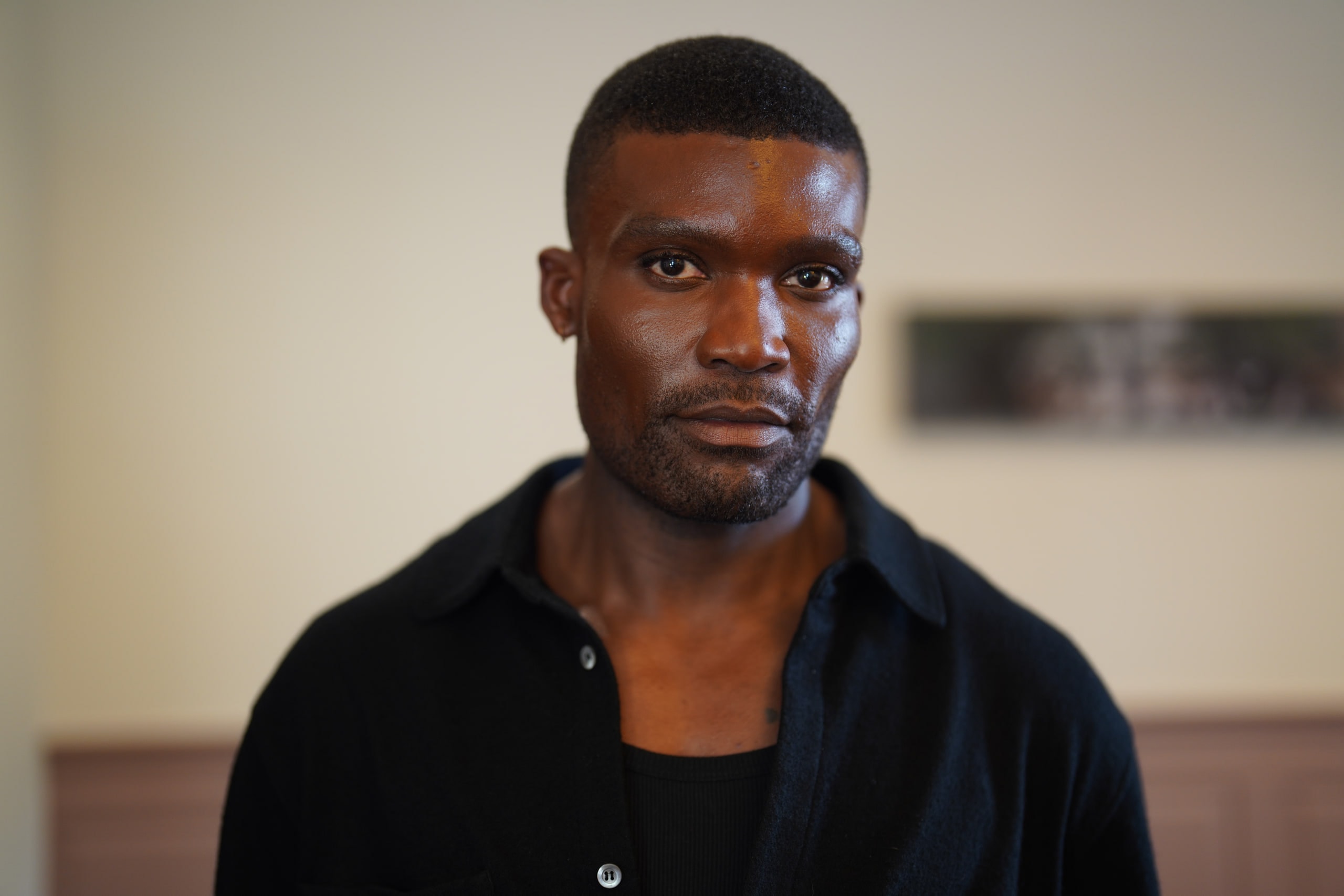 Michael Solomon in a black shirt with a softly blurred interior behind him.