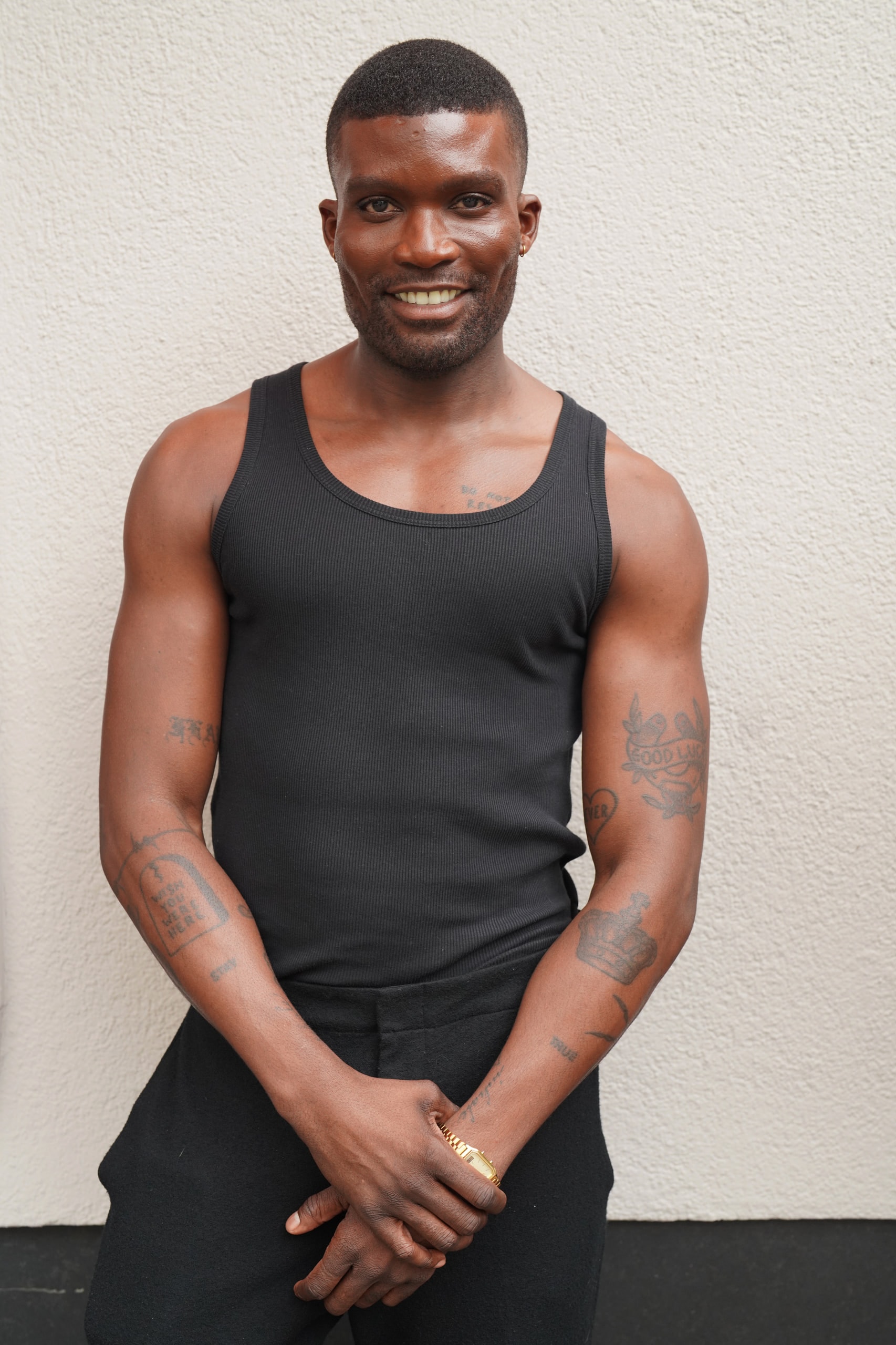 Michael Solomon smiling in a black vest, hands clasped in front of him.