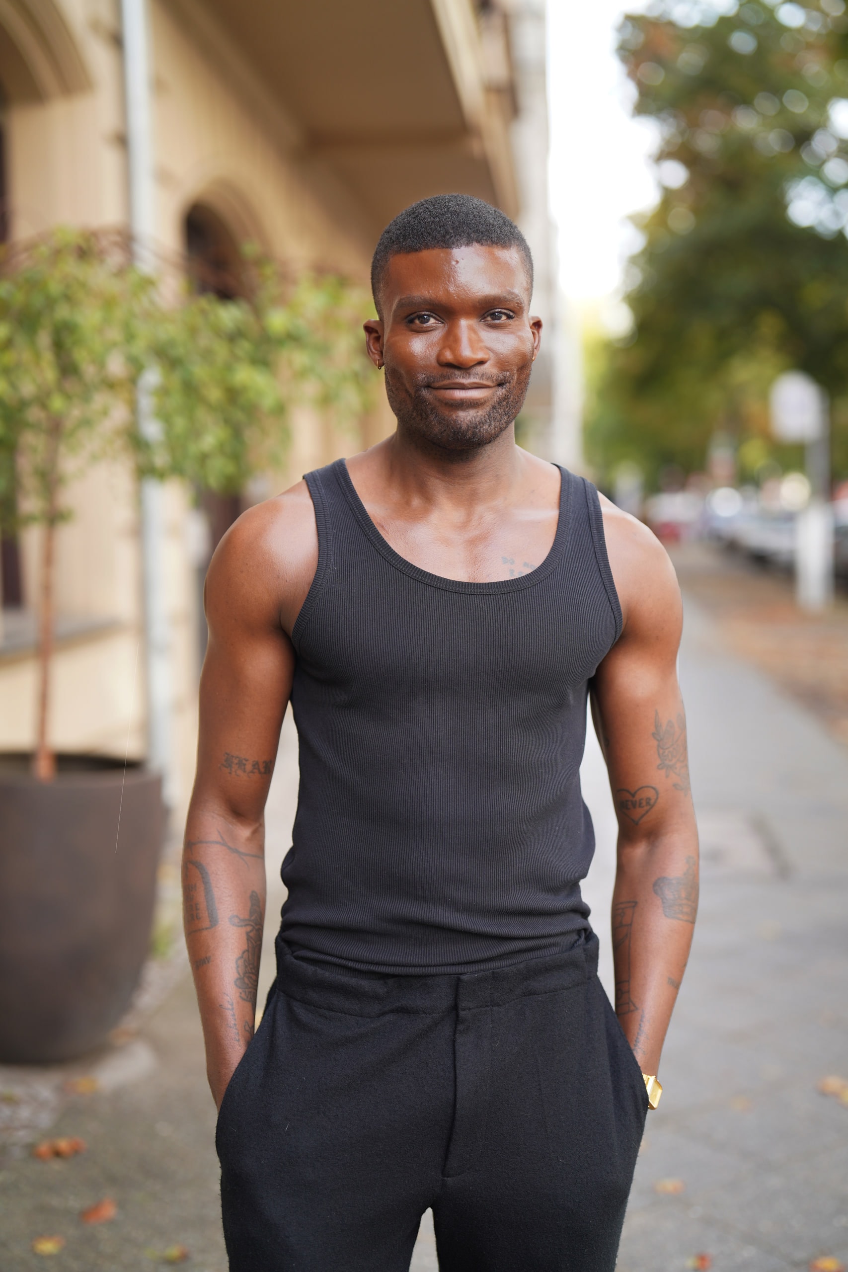 Michael Solomon standing on a Berlin pavement in a black vest, one hand in his pocket.