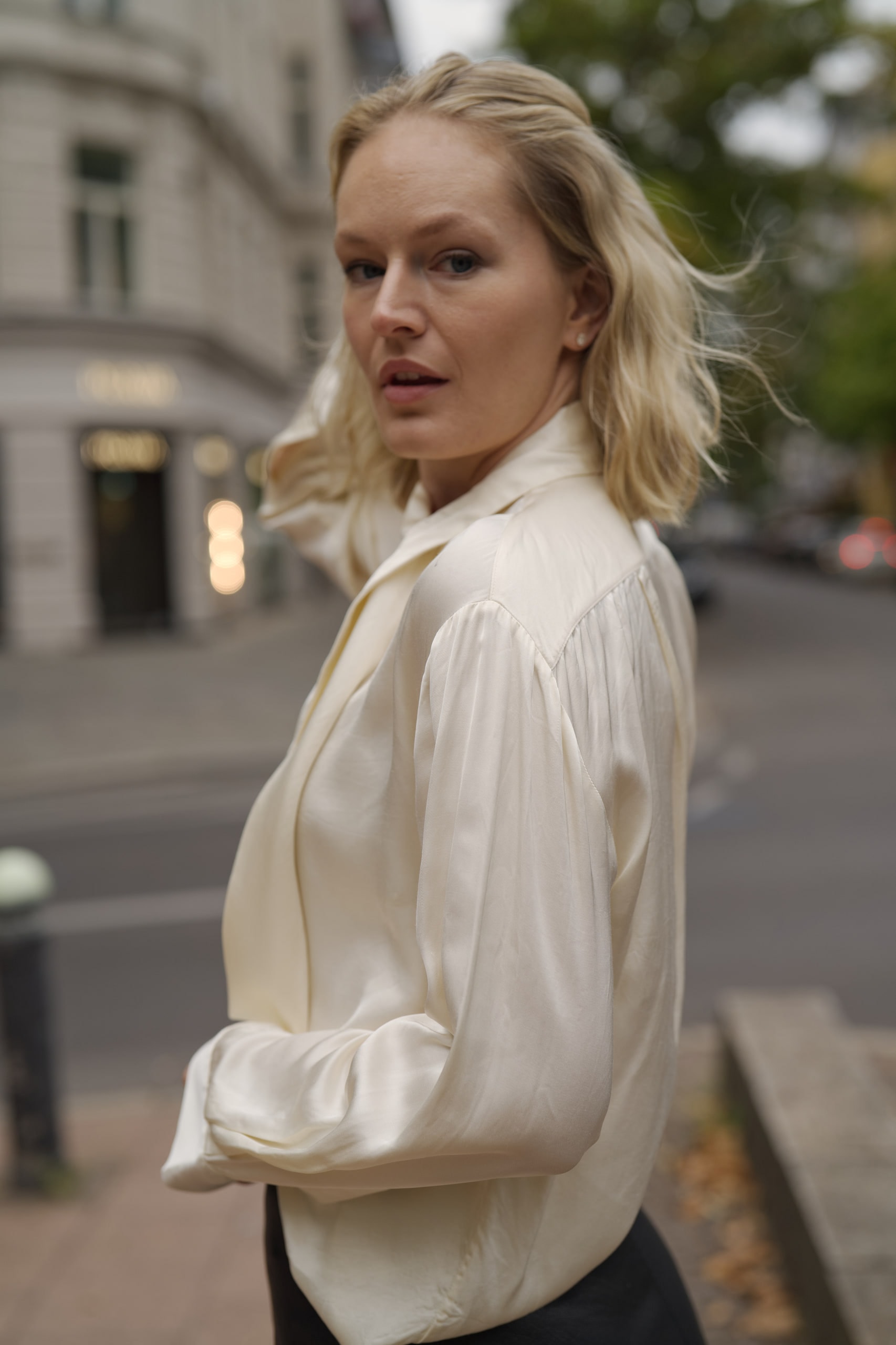 Sophia Repp looking back over her shoulder as her hair moves, a Berlin street behind her.