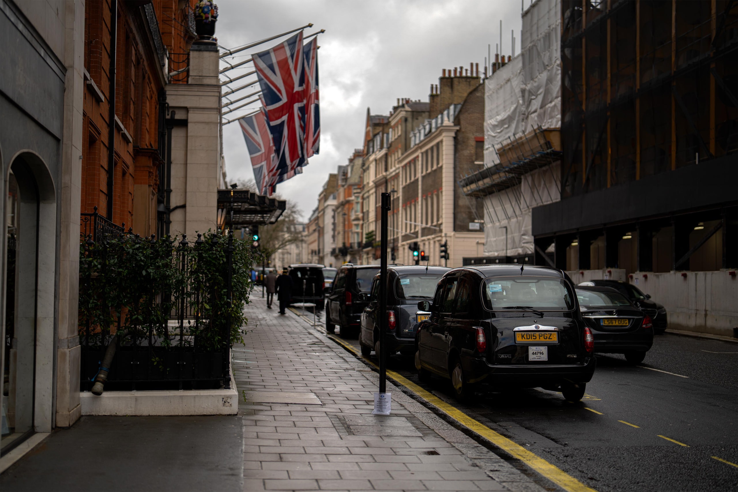 Union flags hanging above black cabs on a grey afternoon.