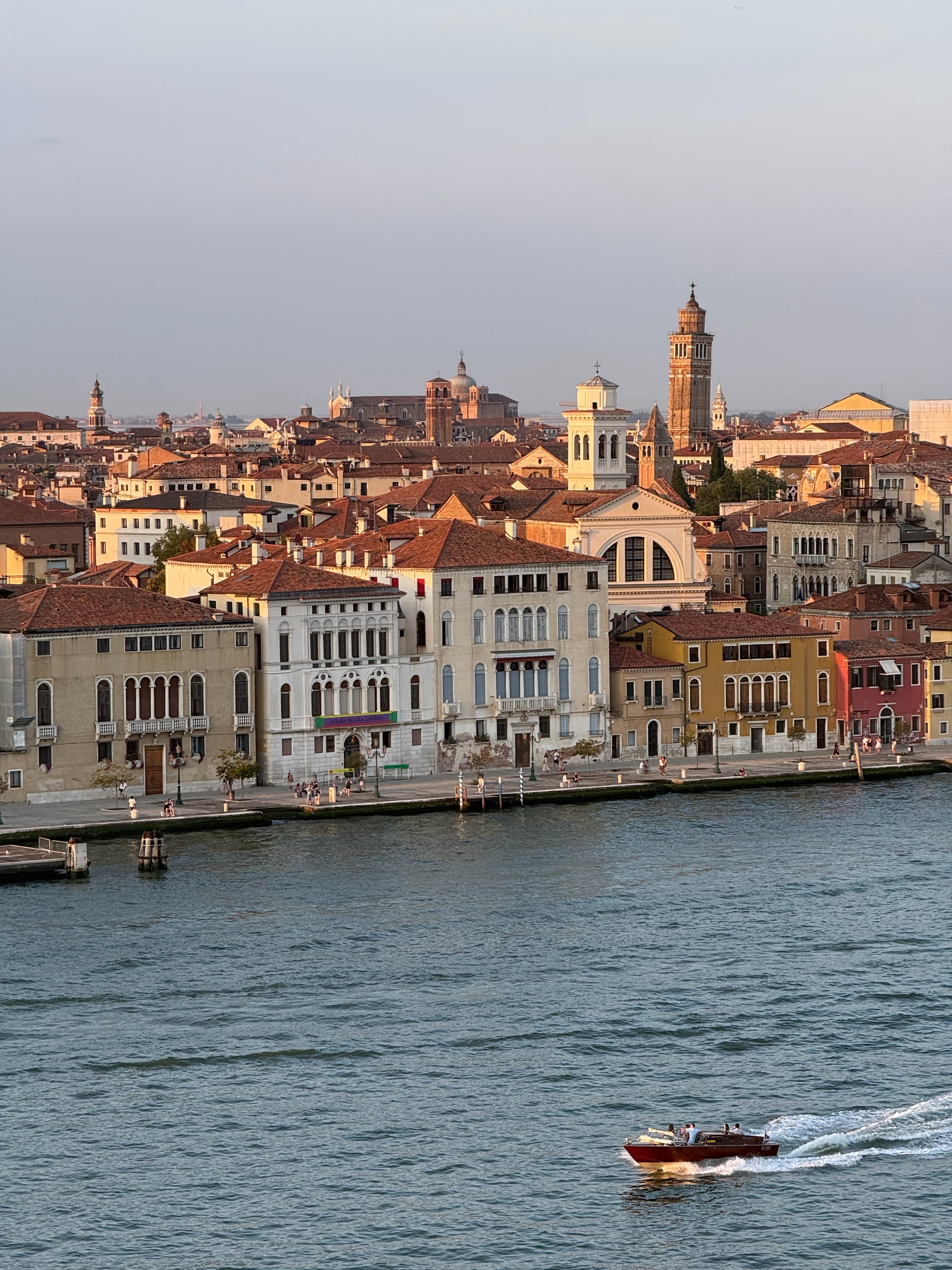 A motorboat crossing the Giudecca Canal below the waterfront buildings.